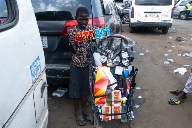 Fig. 22, Abu’s mobile shop with a little boy holding up a pre-made sticker